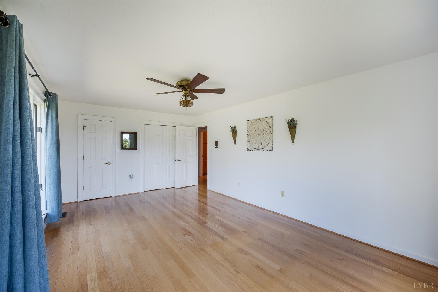 355 Dyson Road Amherst, VA 24521 - Photo 51 of 96 a view of empty room with wooden floor and fan