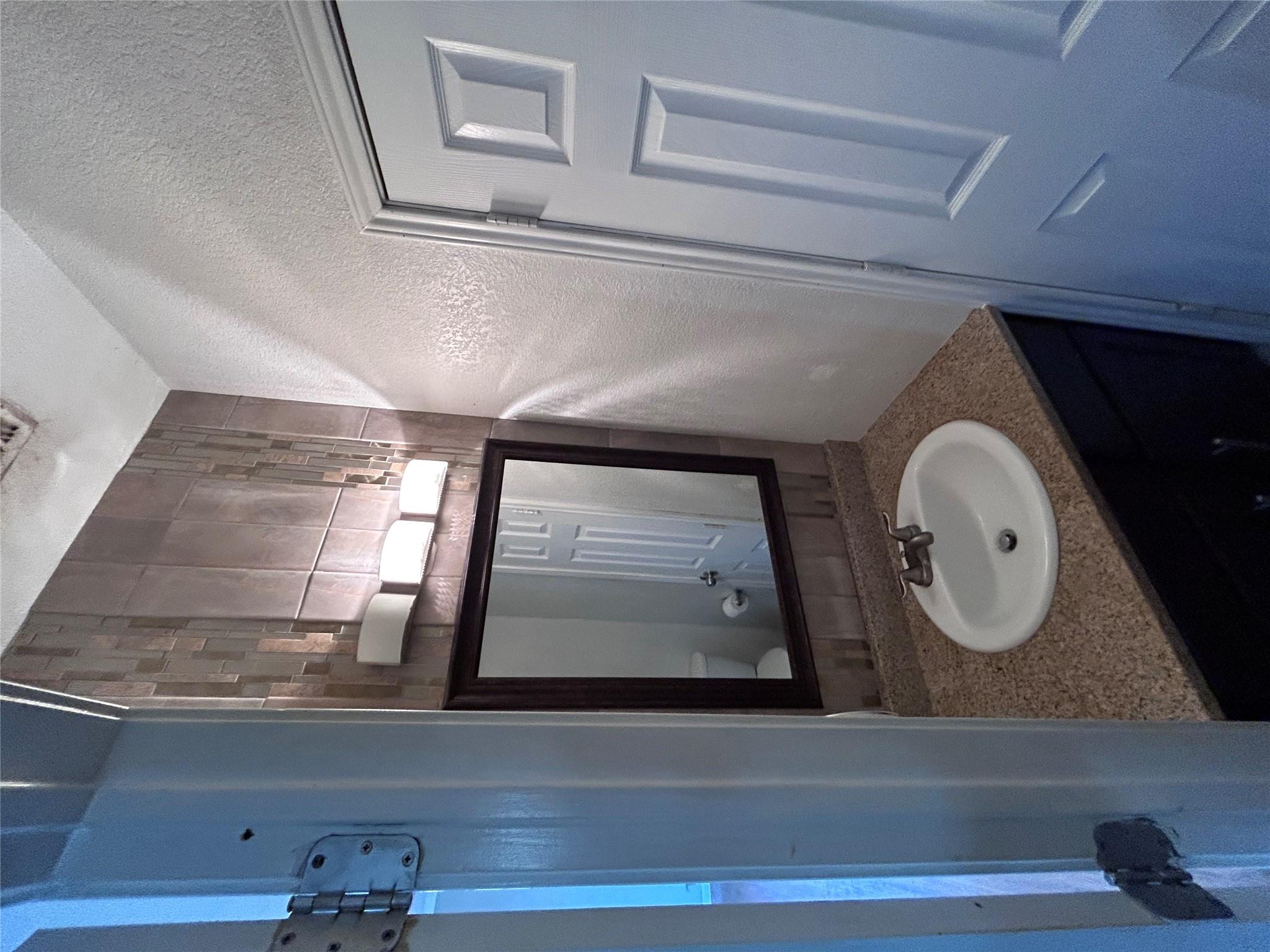 5708 Spring Meadow Road, Unit B Austin, TX 78744 - Photo 3 of 23 Bathroom featuring a textured wall and vanity