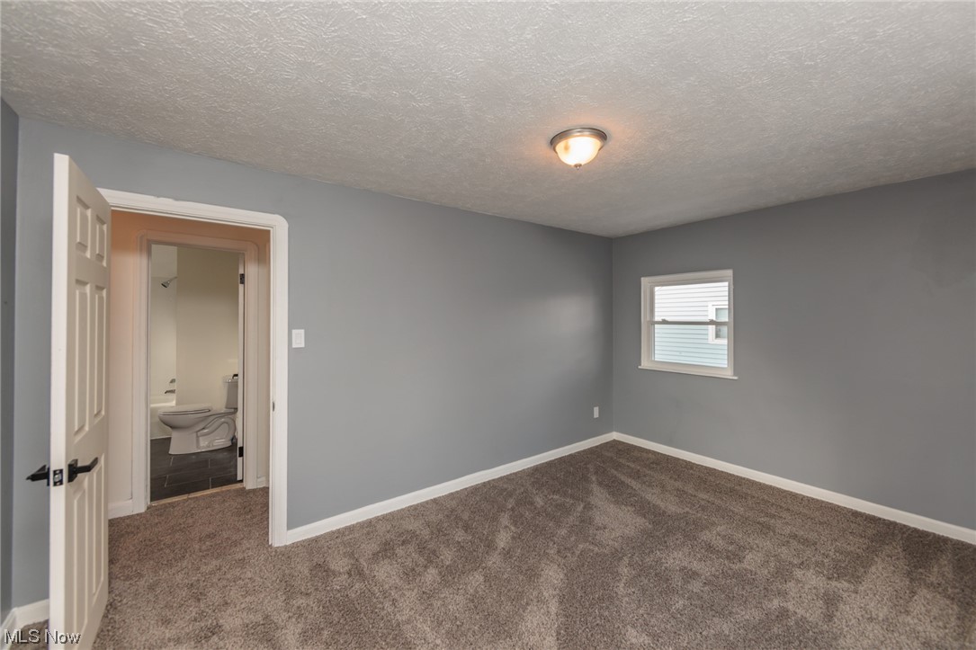 3880 Strandhill Road Cleveland, OH 44128 - Photo 21 of 33 Spare room with dark carpet and a textured ceiling