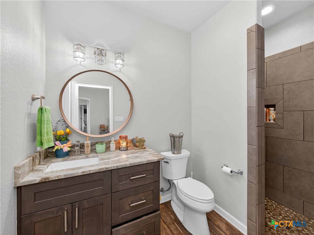 494 Flash Circle Luling, TX 78648 - Photo 20 of 44 a bathroom with a toilet a sink and a mirror