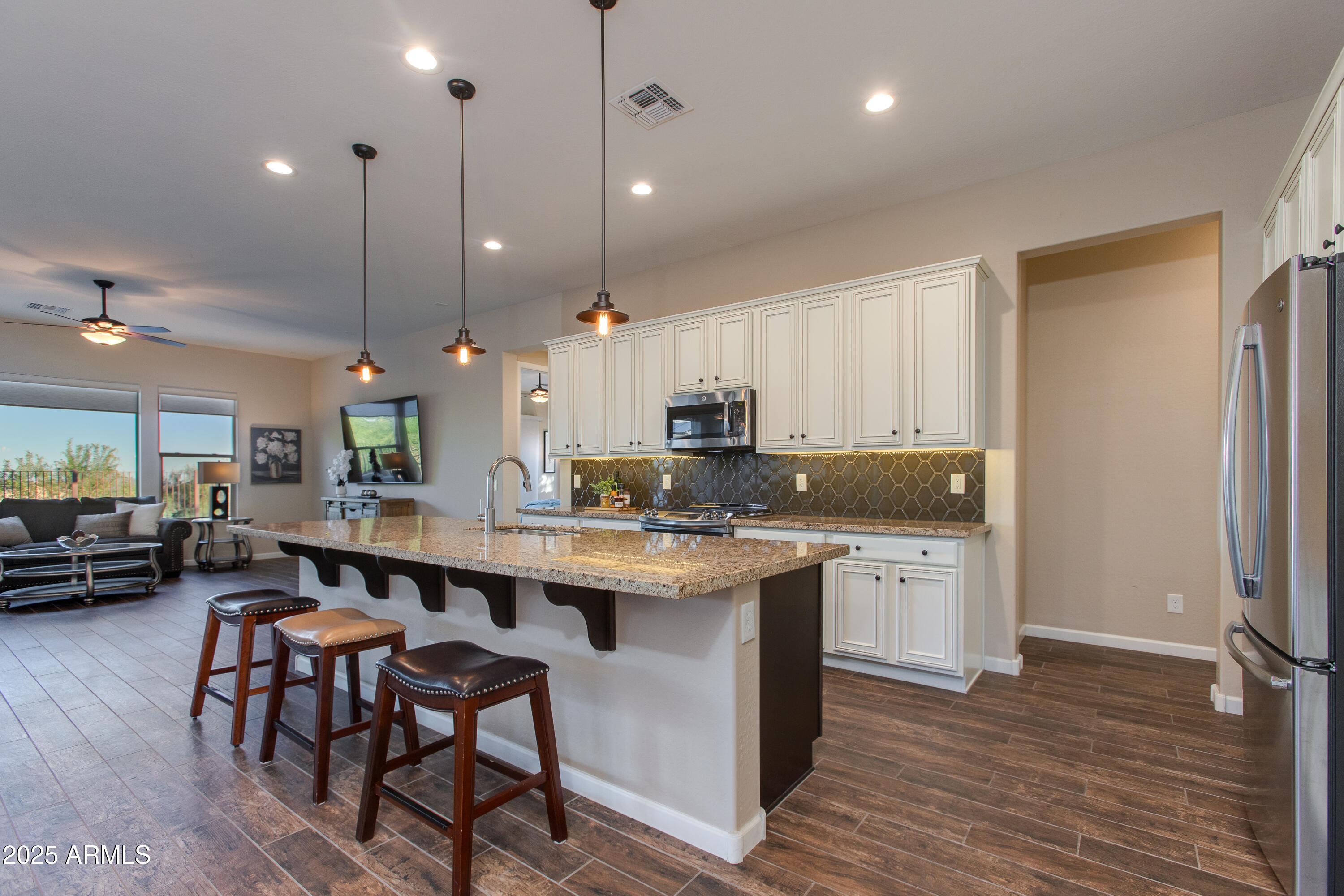 3675 Gold Ridge Road Wickenburg, AZ 85390 - Photo 28 of 66 a kitchen with stainless steel appliances granite countertop a stove a sink a kitchen island with chairs and wooden floor