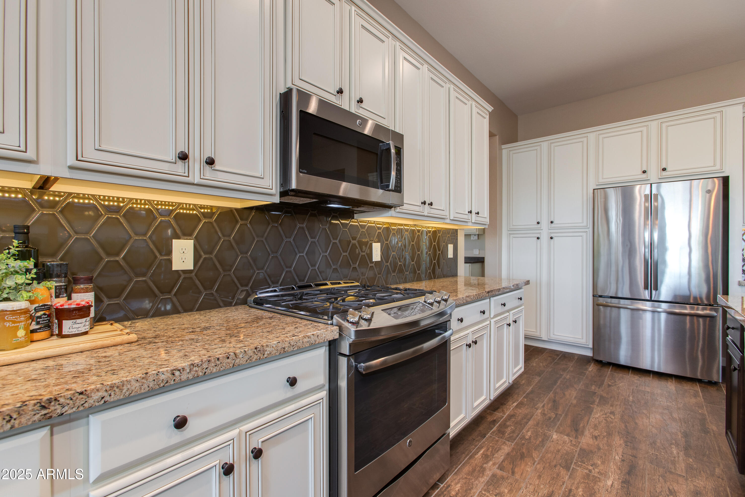 3675 Gold Ridge Road Wickenburg, AZ 85390 - Photo 31 of 66 a kitchen with stainless steel appliances granite countertop a stove top oven a refrigerator a sink and dishwasher with wooden floor