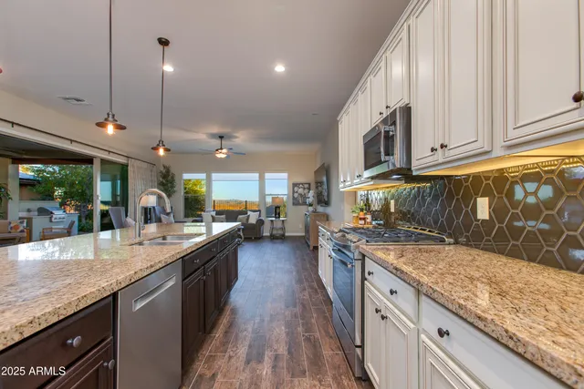 a view of a patio with couches table and chairs and potted plants