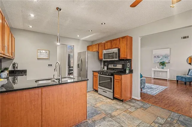 a large kitchen with stainless steel appliances a stove a sink a microwave and a refrigerator