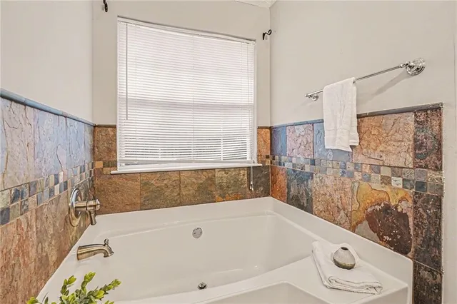 a bathroom with a tub a window and a shower