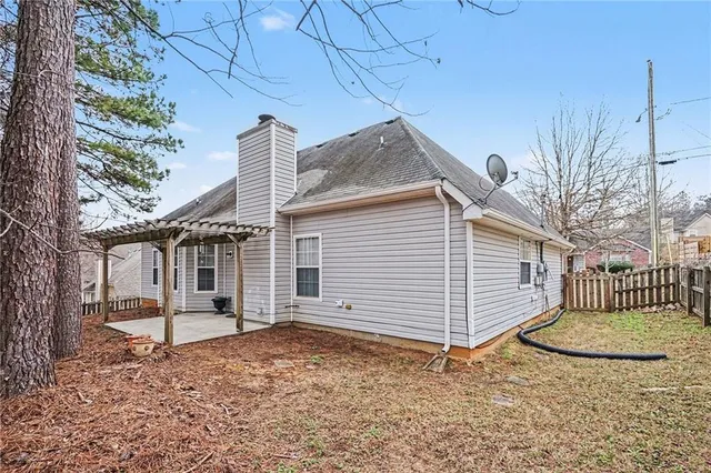 a view of a house with a fence and a tree