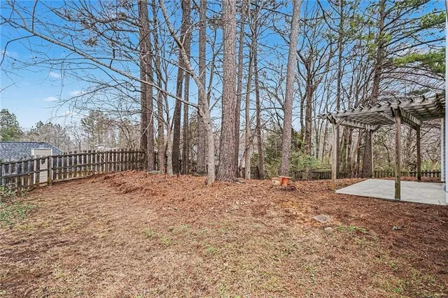 a view of a yard with wooden fence