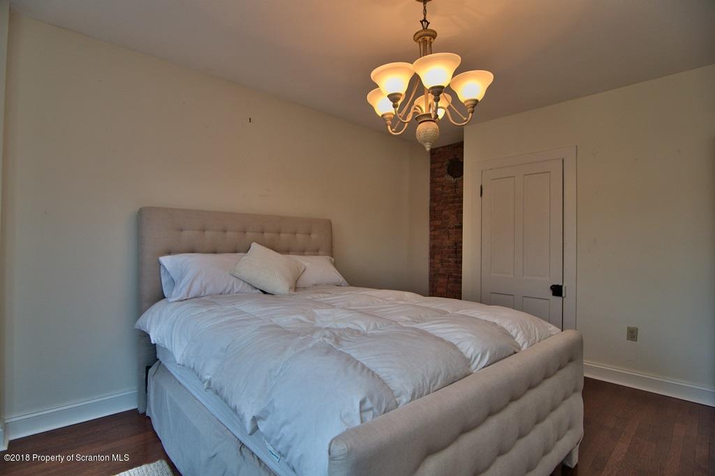754 Green Ridge Street Scranton, PA 18509 - Photo 56 of 77 a bedroom with a bed and a chandelier
