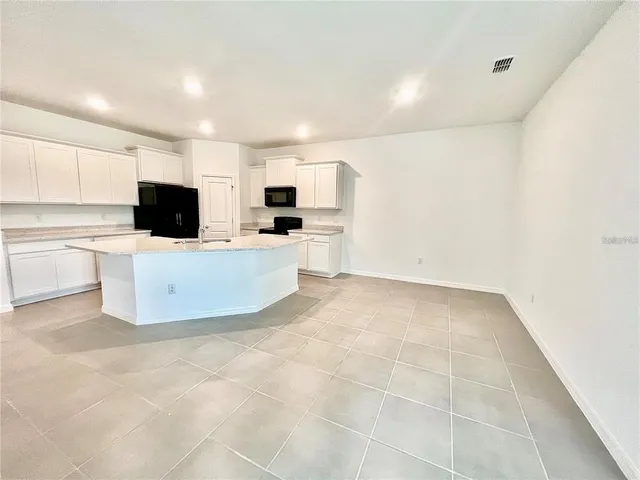 a kitchen with a sink a microwave and cabinets