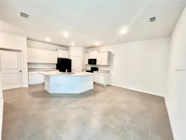 a view of kitchen with microwave and cabinets
