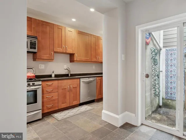 a kitchen with stainless steel appliances granite countertop a stove a sink and a refrigerator