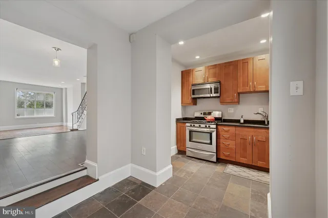 a kitchen with stainless steel appliances granite countertop a stove top oven a sink and dishwasher