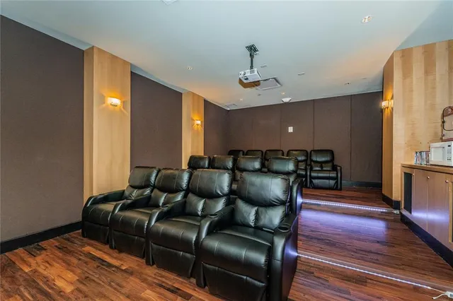 a media room with lots of chairs and wooden floor