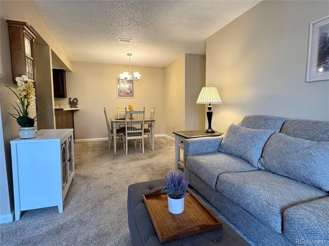 a living room with furniture and a chandelier