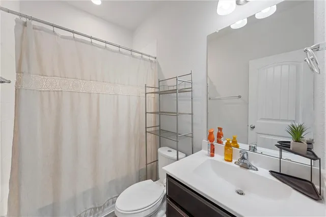 a bathroom with a sink a toilet and shower curtain