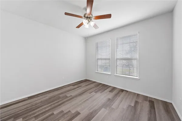 an empty room with a window and a ceiling fan