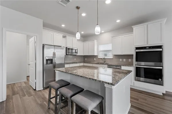 a kitchen with a center island and stainless steel appliances