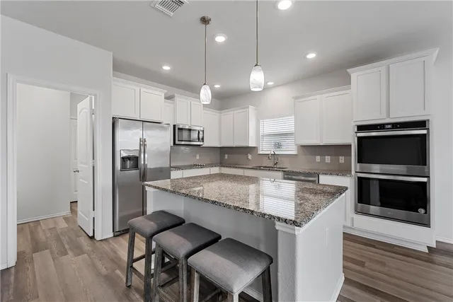 a kitchen with a center island and stainless steel appliances