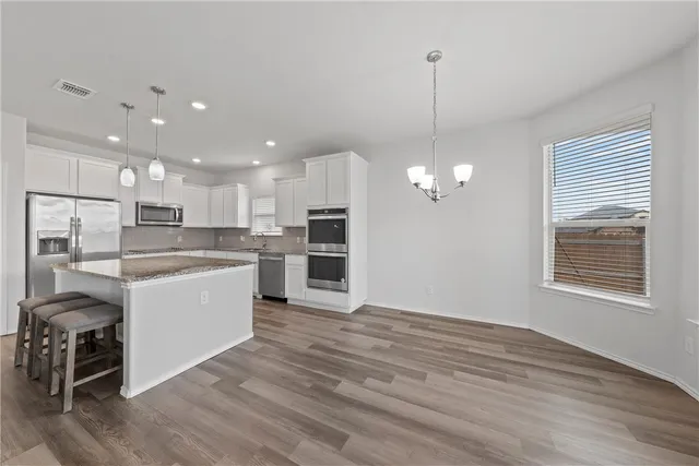 a view of a kitchen with center island and stainless steel appliances