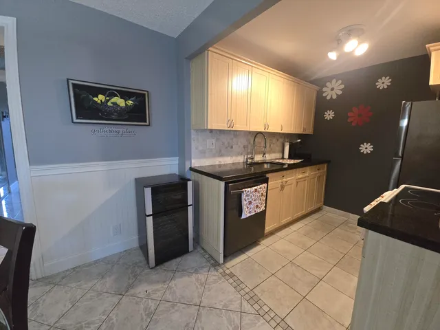 a kitchen with stainless steel appliances granite countertop a stove a sink and a refrigerator