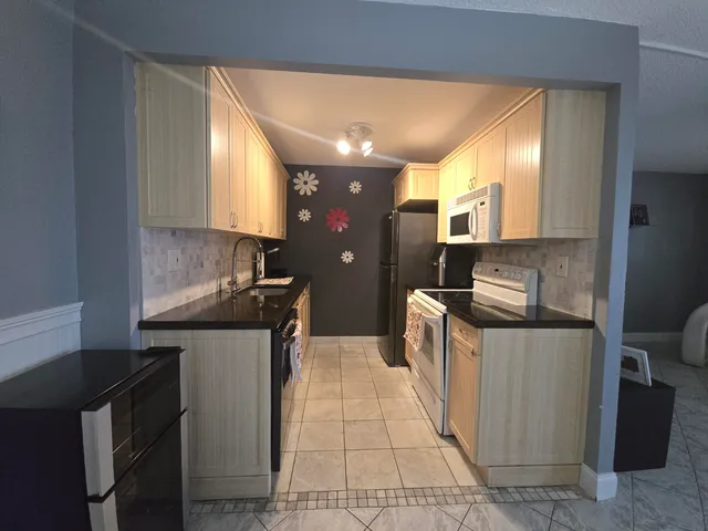 a kitchen with stainless steel appliances granite countertop a sink and a stove