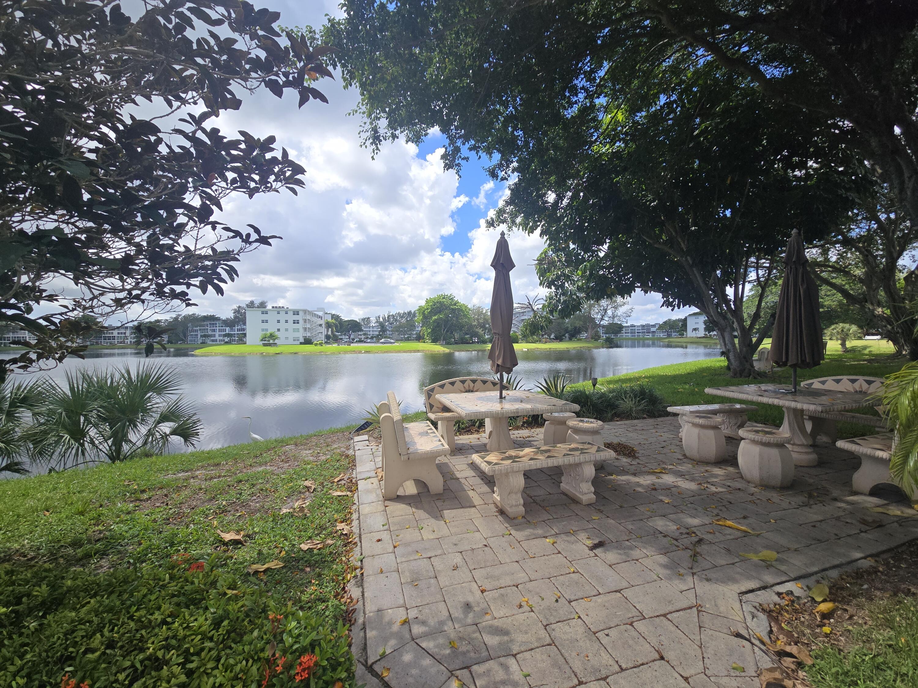 2010 Westbury F, Unit 2010 Deerfield Beach, FL 33442 - Photo 4 of 28 a view of a lake with tables and chairs