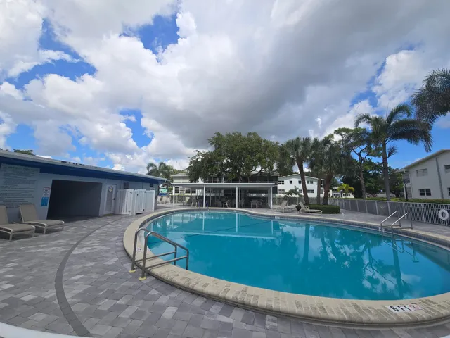 a swimming pool with outdoor seating and barbeque oven