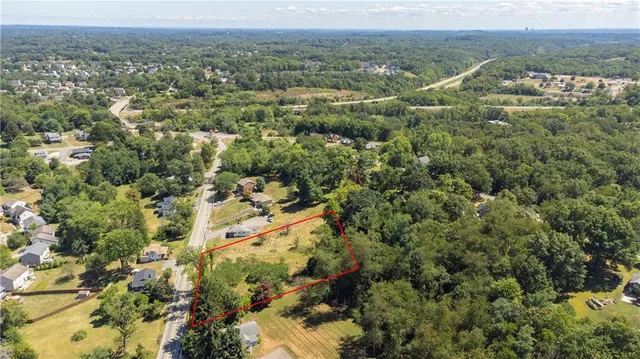 an aerial view of residential houses with outdoor space and trees