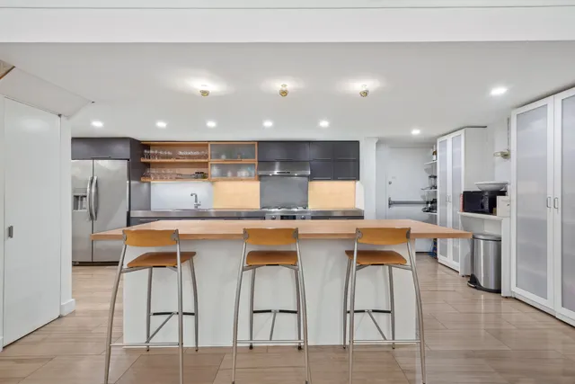 a kitchen with stainless steel appliances kitchen island granite countertop a table and chairs in it