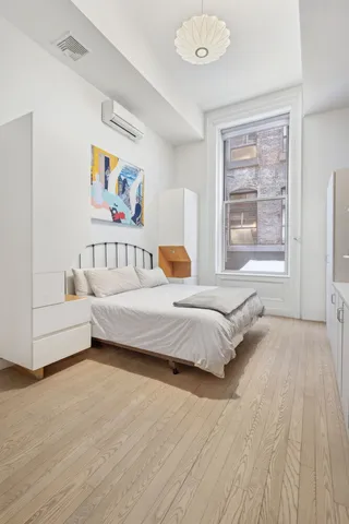 a spacious bedroom with a bed a couch and a window