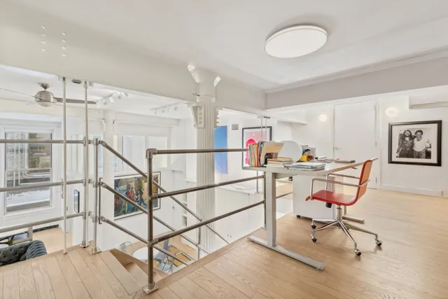 a view of a room with wooden floor and chairs