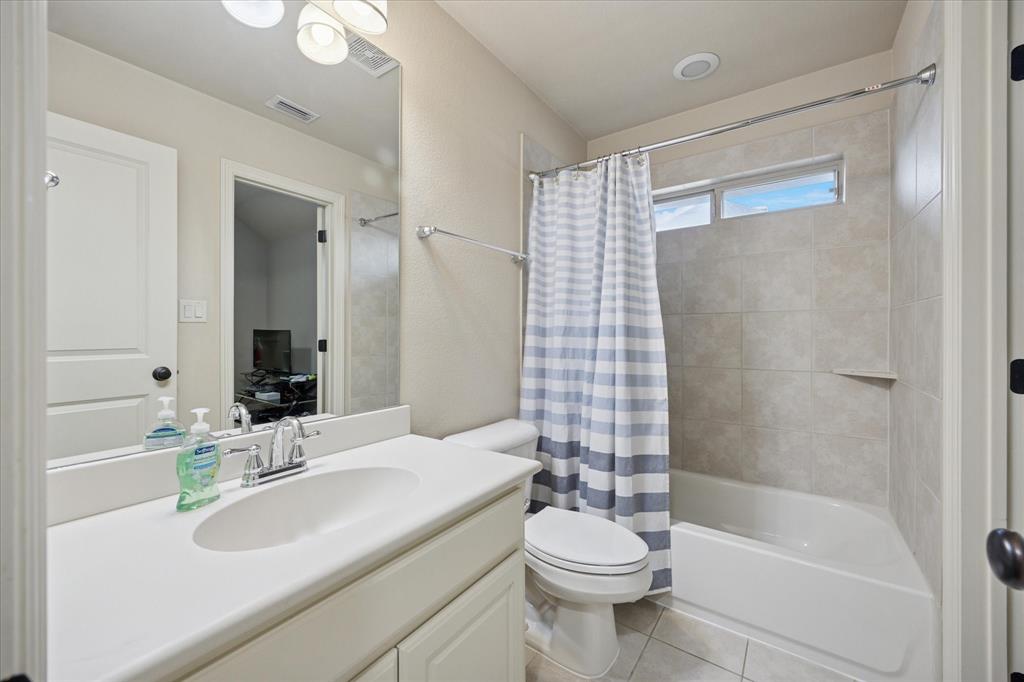 580 Butchart Drive Prosper, TX 75078 - Photo 31 of 40 Bathroom featuring tile patterned floors, toilet, shower / bath combination with curtain, and vanity