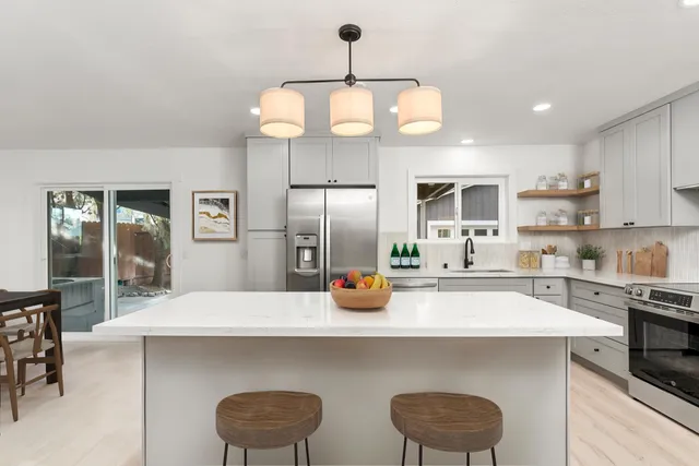 a kitchen with stainless steel appliances a stove a sink and cabinets