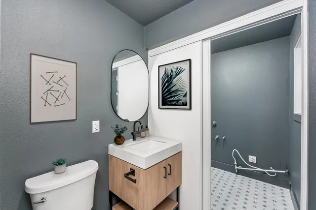 a bathroom with a sink toilet and a mirror