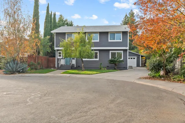 a view of a house with a yard and palm trees