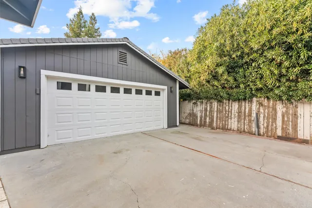 a view of backyard of house with wooden fence