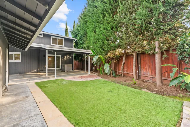 a view of a house with a yard and sitting area