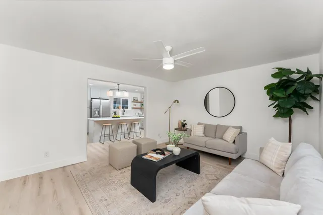 a living room with furniture a chandelier and a potted plant