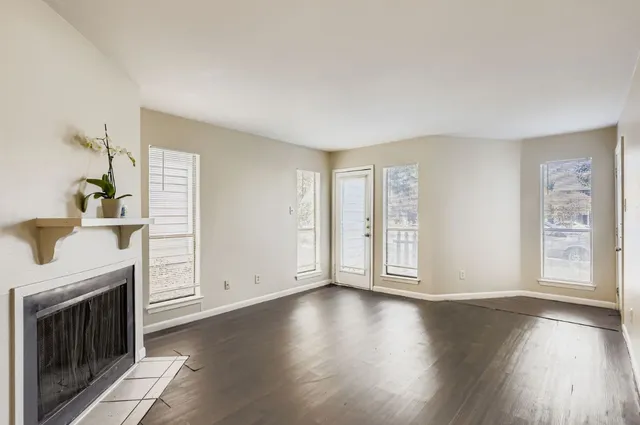 a view of an empty room with a fireplace and a window