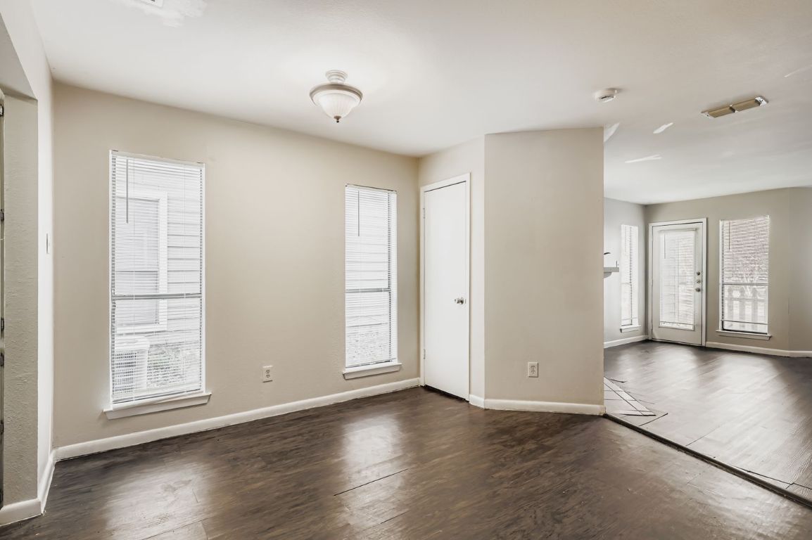 2005 West Loop, Unit A Austin, TX 78758 - Photo 2 of 11 an empty room with wooden floor and windows