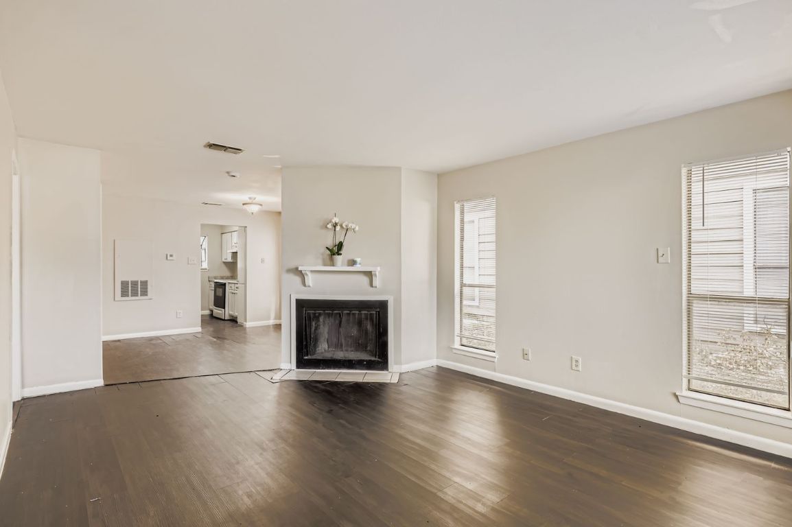 2005 West Loop, Unit A Austin, TX 78758 - Photo 3 of 11 a view of a livingroom with wooden floor a fireplace and window