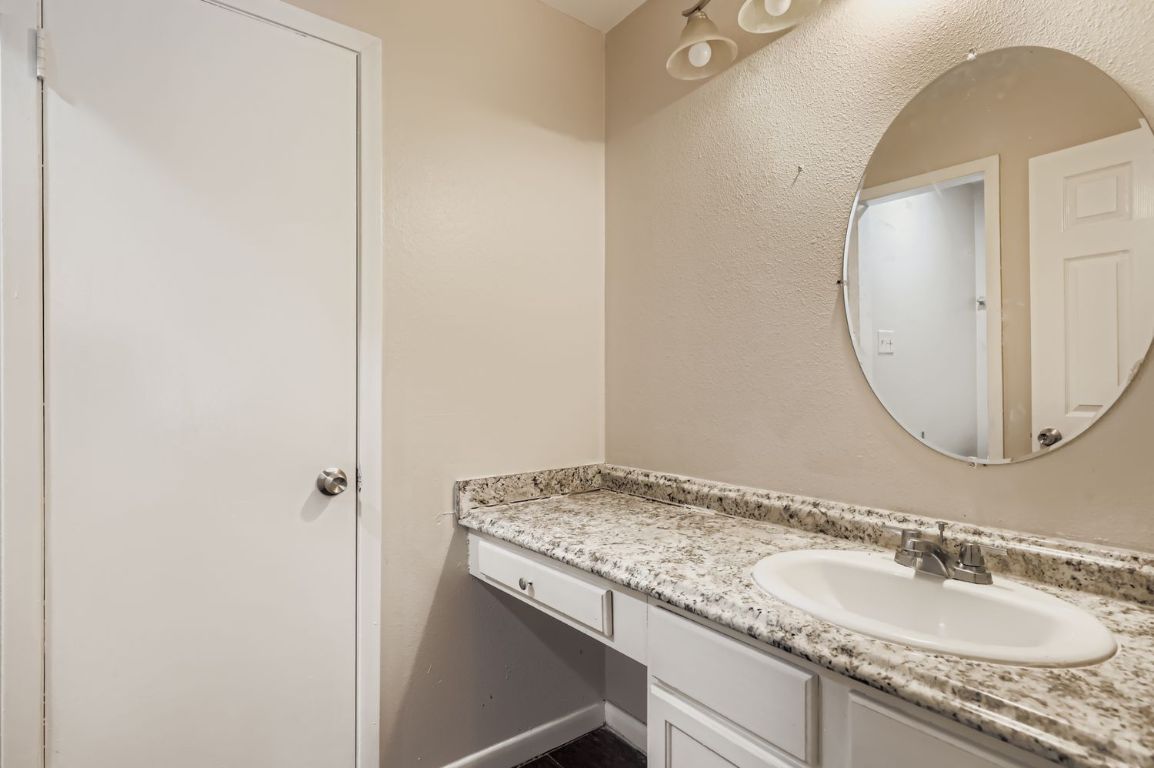 2005 West Loop, Unit A Austin, TX 78758 - Photo 7 of 11 a bathroom with a granite countertop sink and a mirror