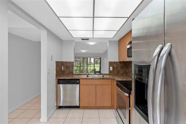 a kitchen with stainless steel appliances granite countertop a stove a refrigerator and a sink