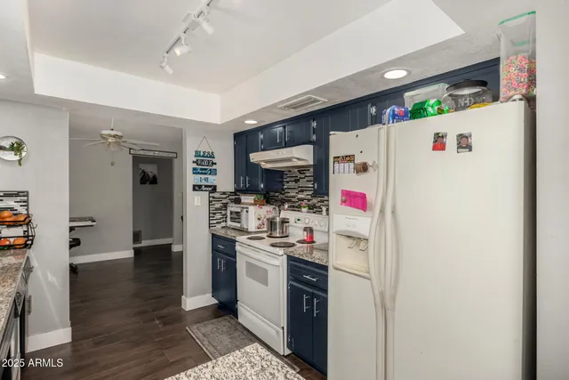 a kitchen with stainless steel appliances granite countertop a refrigerator and a stove