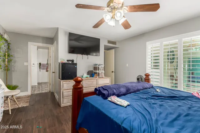 a bedroom with a bed a flat screen tv and a chandelier
