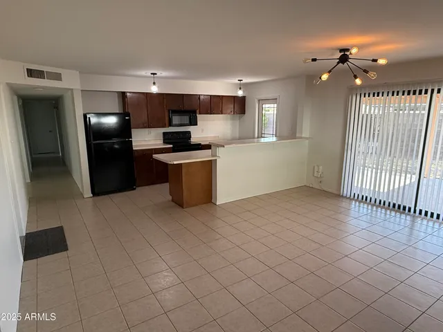 a kitchen with stainless steel appliances kitchen island granite countertop a refrigerator and a sink