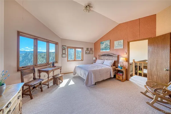 a spacious bedroom with a bed a table and large windows
