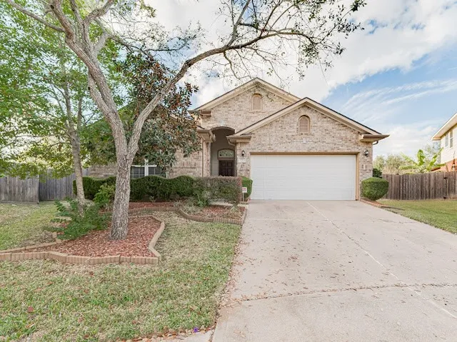 front view of a house with a yard and an trees