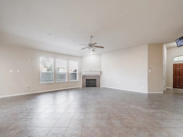 a view of an empty room with a fireplace and a window
