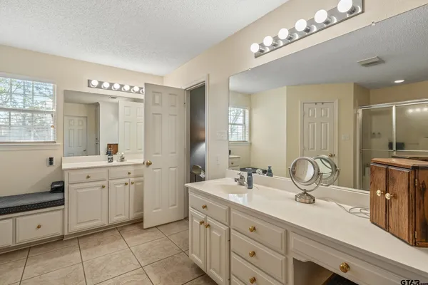 a bathroom with a double vanity sink a mirror and a shower